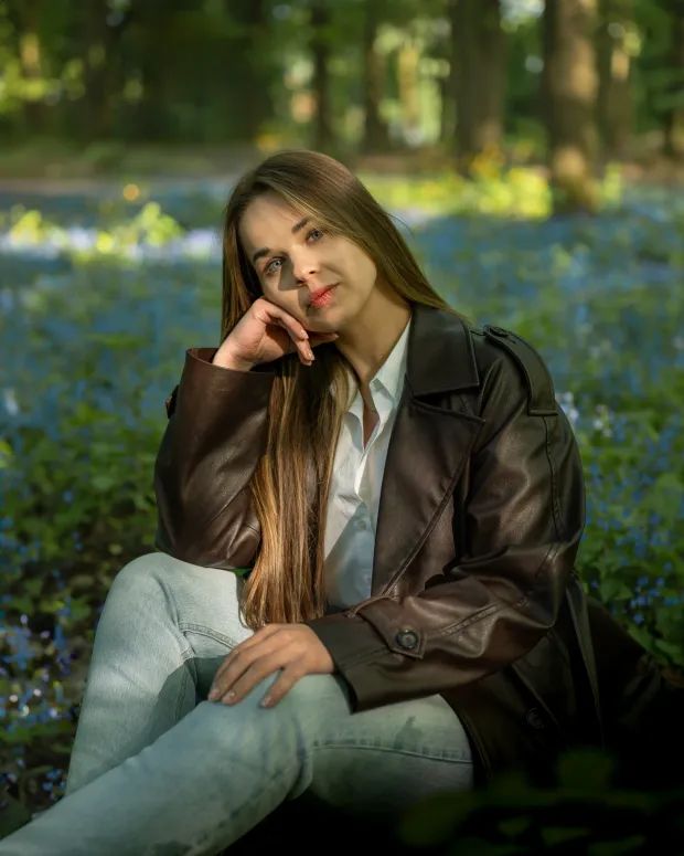 Woman among blue flowers in the forest