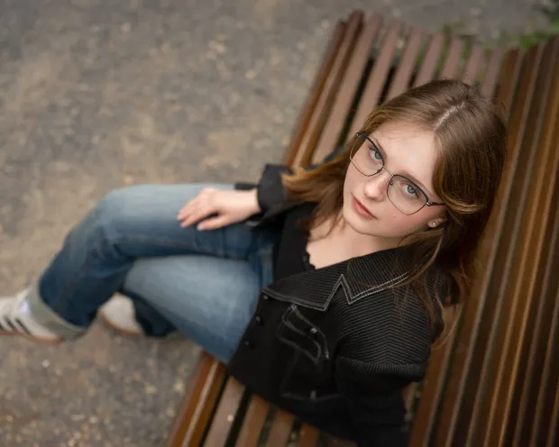 Portrait from above — girl in glasses on a bench