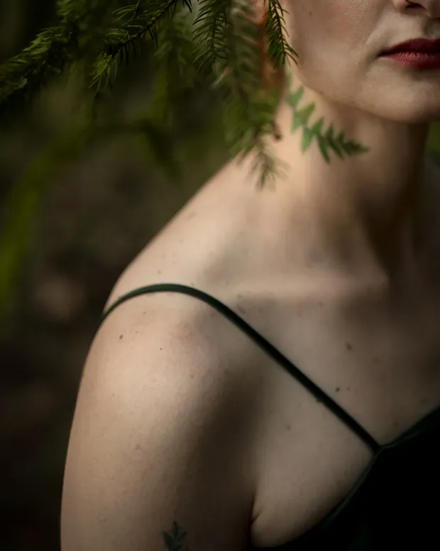 Outdoor female session — shoulder detail among branches